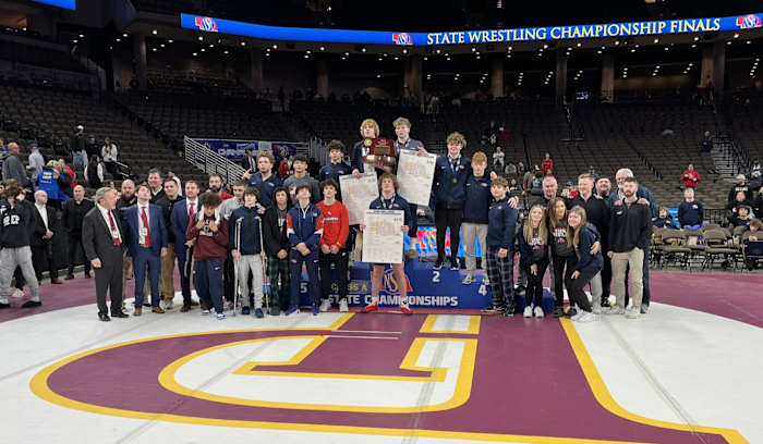 Millard South wrestlers, coaches and team managers come together for a photo after winning the Class A team championship Saturday in downtown Omaha. It was the sixth title in a row and 12th overall for the Patriots. Photo by @nsaahome on X.